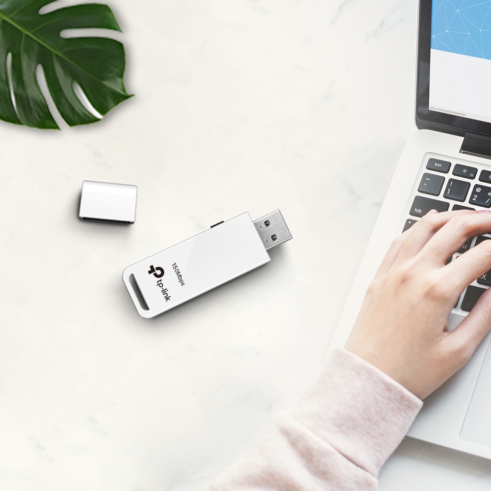 کارت شبکه USB بی‌ سیم تی پی لینک مدل TL-WN727N دربباز کنار لپتاپ